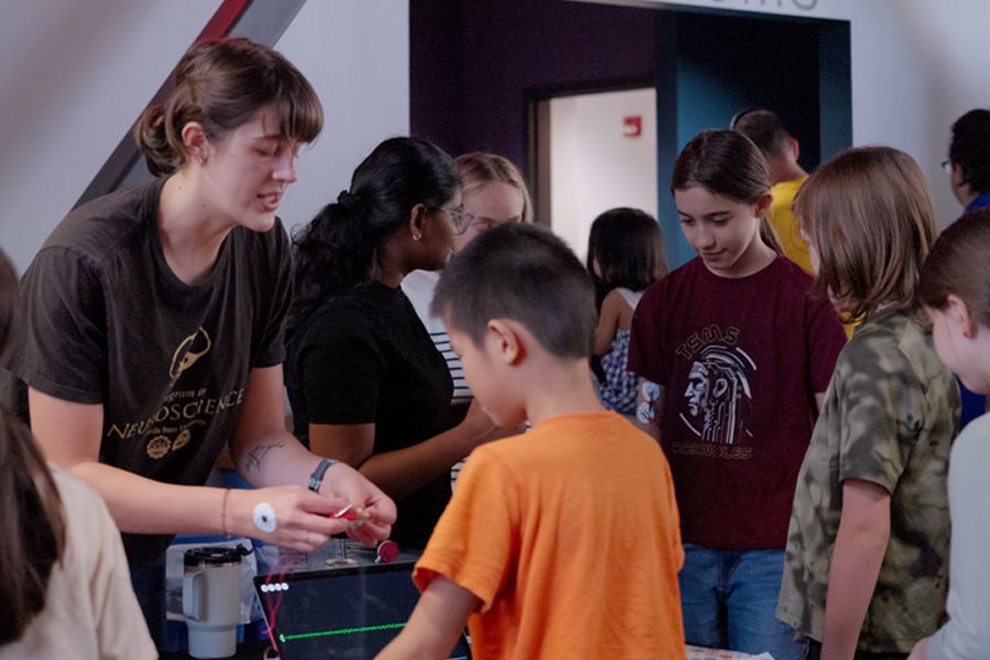 A member of FSU’s Neuroscience Graduate Student Association shares an exhibit with attendees at the 2025 Tallahassee Biotechnology Expo. (Aidan Marengo/FSU iGEM)