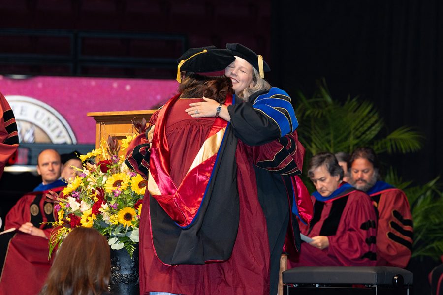 A Florida State University faculty member embraces a graduate during the summer doctoral hooding ceremony, Friday, Aug. 1, 2025, at the Donald L. Tucker Civic Center. (FSU Photography)