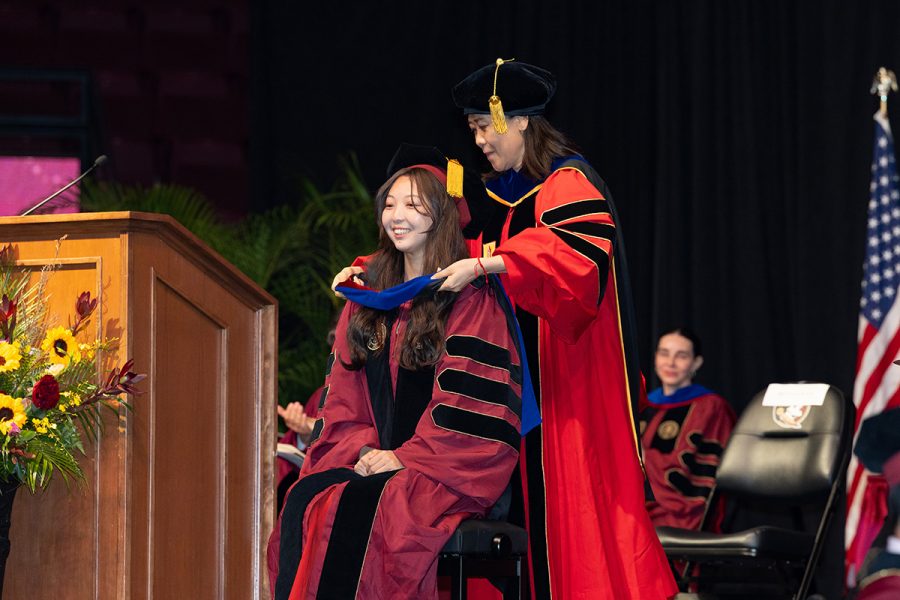 A Florida State University faculty member hoods a graduate during the summer doctoral hooding ceremony, Friday, Aug. 1, 2025, at the Donald L. Tucker Civic Center. (FSU Photography)