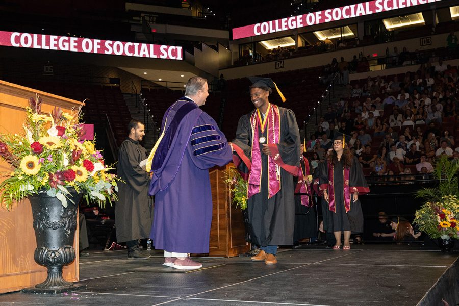 Dean Tim Chapin of the College of Social Sciences and Public Policy shakes hands with a graduate during one of the summer commencement ceremonies, Friday, Aug. 1, 2025, at the Donald L. Tucker Civic Center. (FSU Photography)