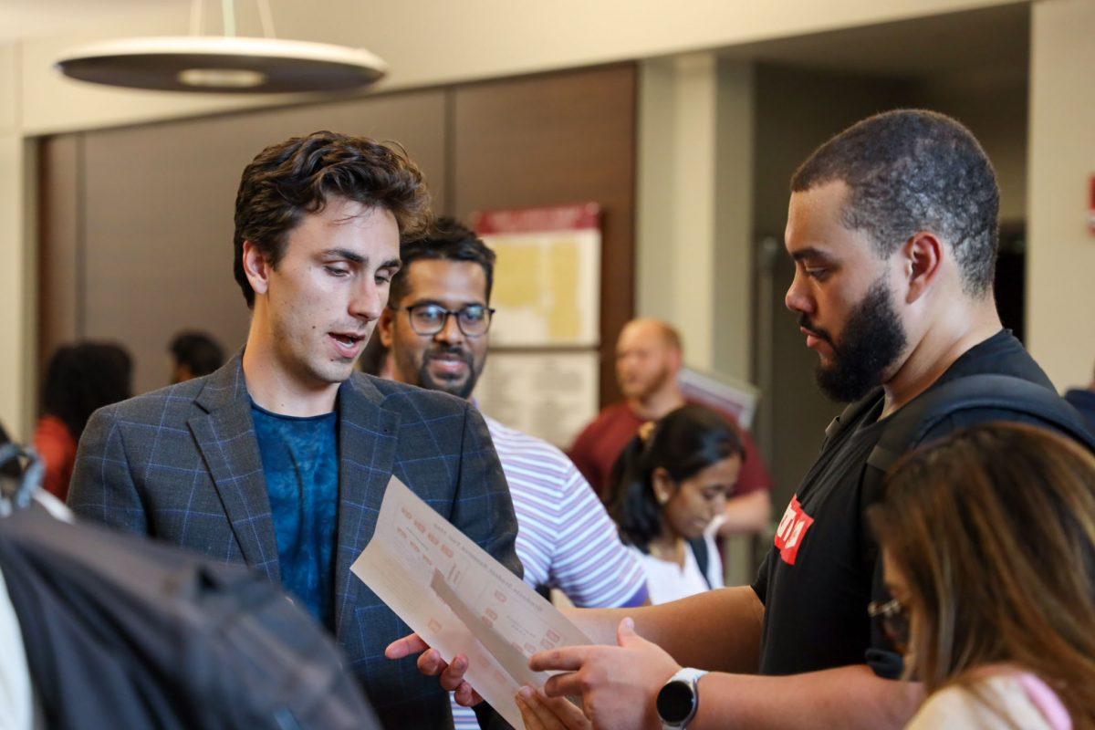 Hugh Long (left), student success analyst for the Graduate Student Resource Center, speaks with a student at the annual Graduate Student Resource Fair. (Logan Lowery/Florida State University)