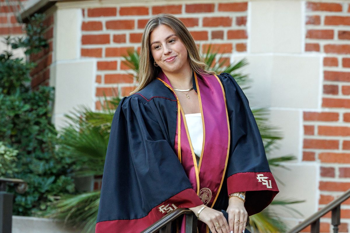 A graduate poses for photos at FSU’s historic Westcott Building.