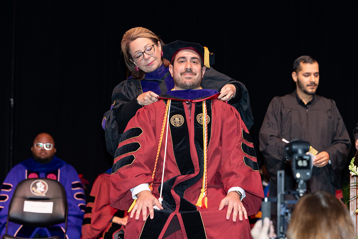 A Florida State University faculty member hoods a graduate during the summer doctoral hooding ceremony, Friday, Dec. 12, 2025, at the Donald L. Tucker Civic Center. (Bill Lax/ Florida State University)