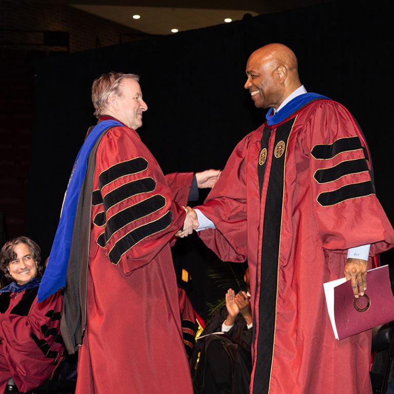 J. Leonard Hamilton, retired head men’s basketball coach at Florida State University, and Florida State University President Richard McCullough share a handshake during fall commencement at the Donald L. Tucker Civic Center, Friday, Dec. 12, 2025. (Bill Lax/ Florida State University)