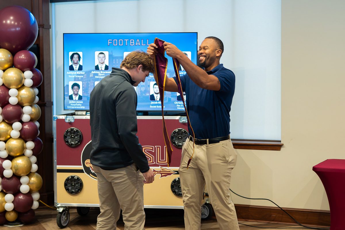 An FSU student-athlete is given their stole at a Student Athlete Academic Services graduation brunch.