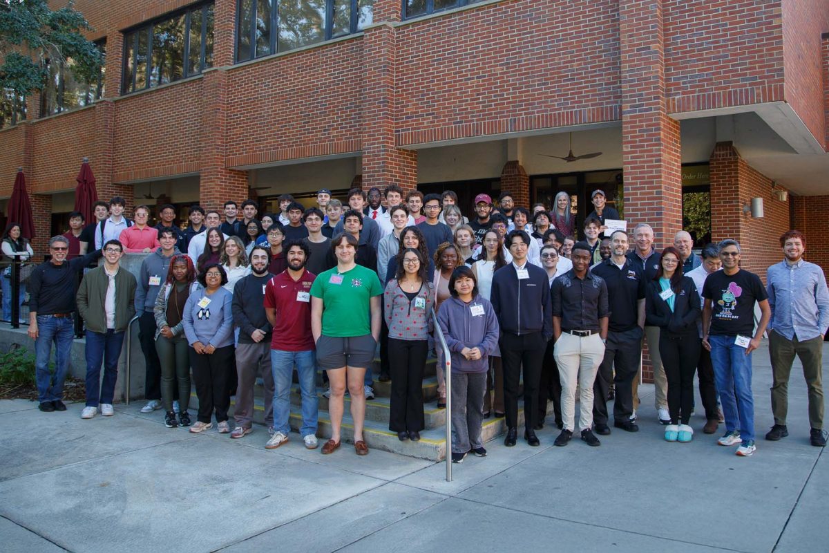 Many people stand on stairs smiling for a photo.