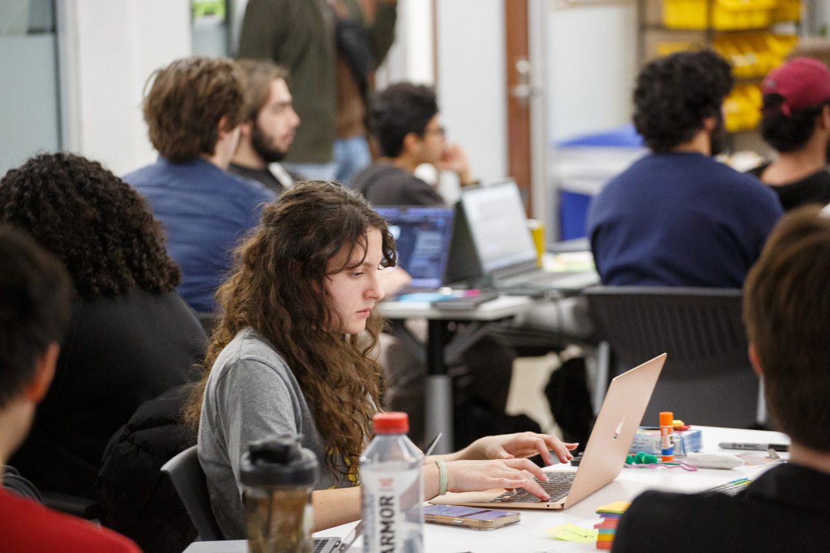 A student, sits a table going on their computer.