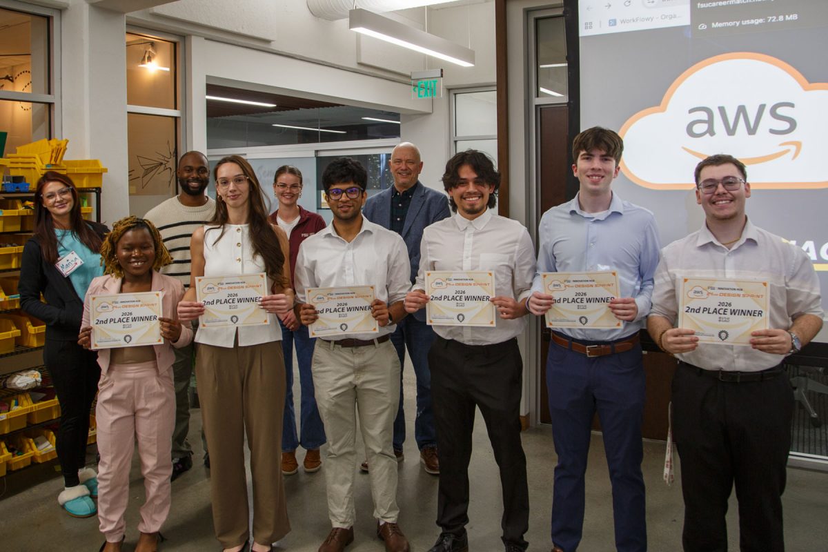 Five students holding certificates, stand in front of a panel of four judges.