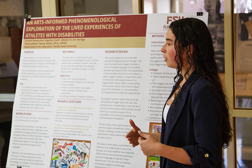 A student presents information from a research poster.