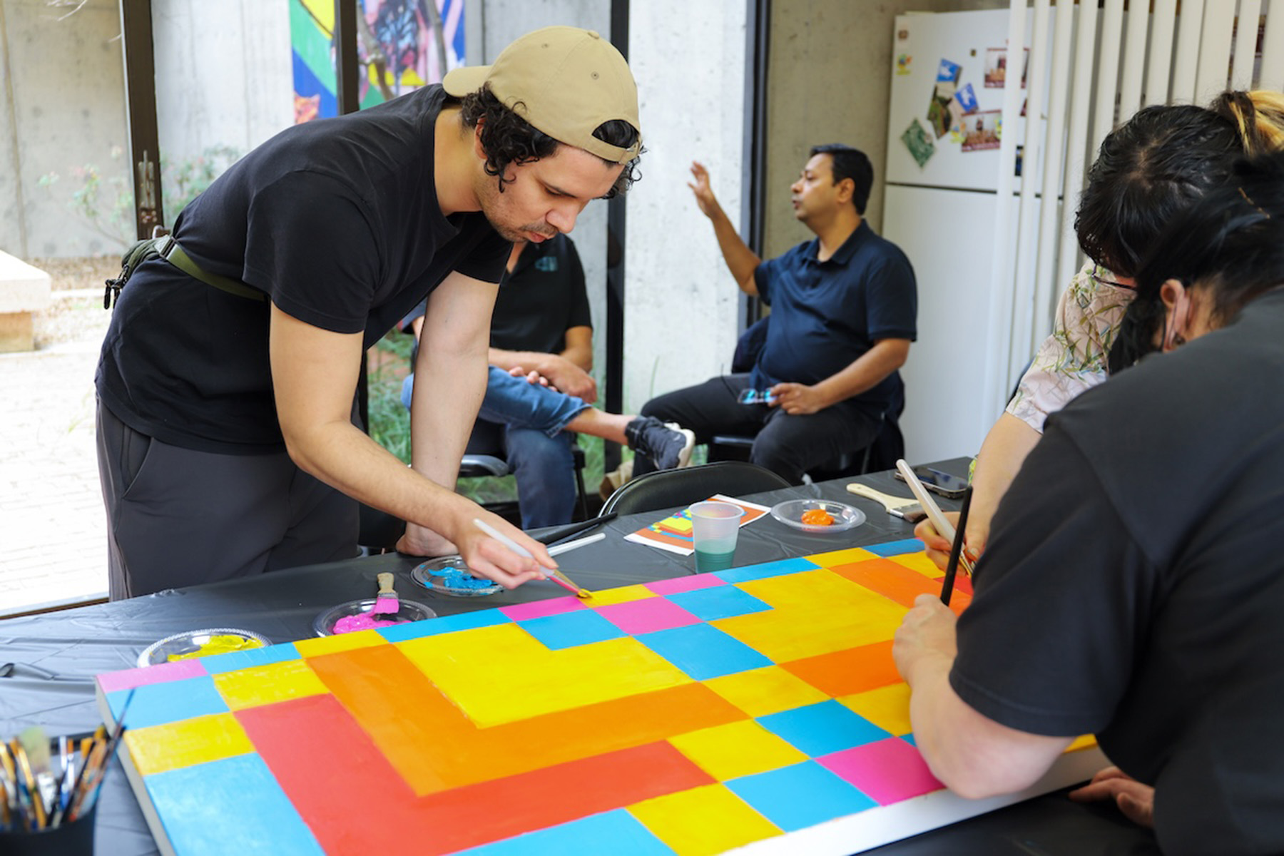 Person leans down to a table and paints