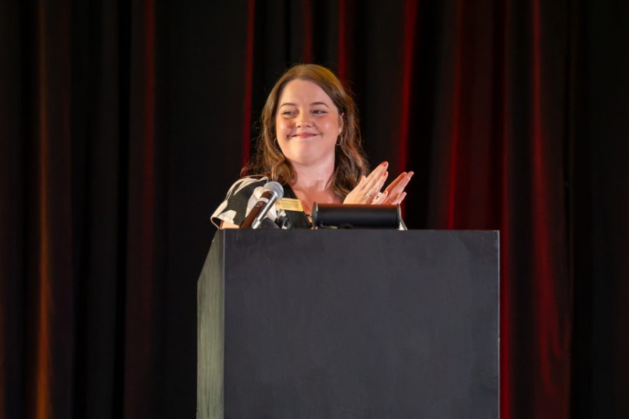 White woman speaking at podium.