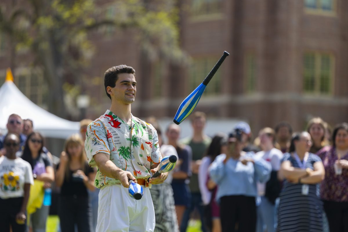 A man juggles with many people in the backround blurred