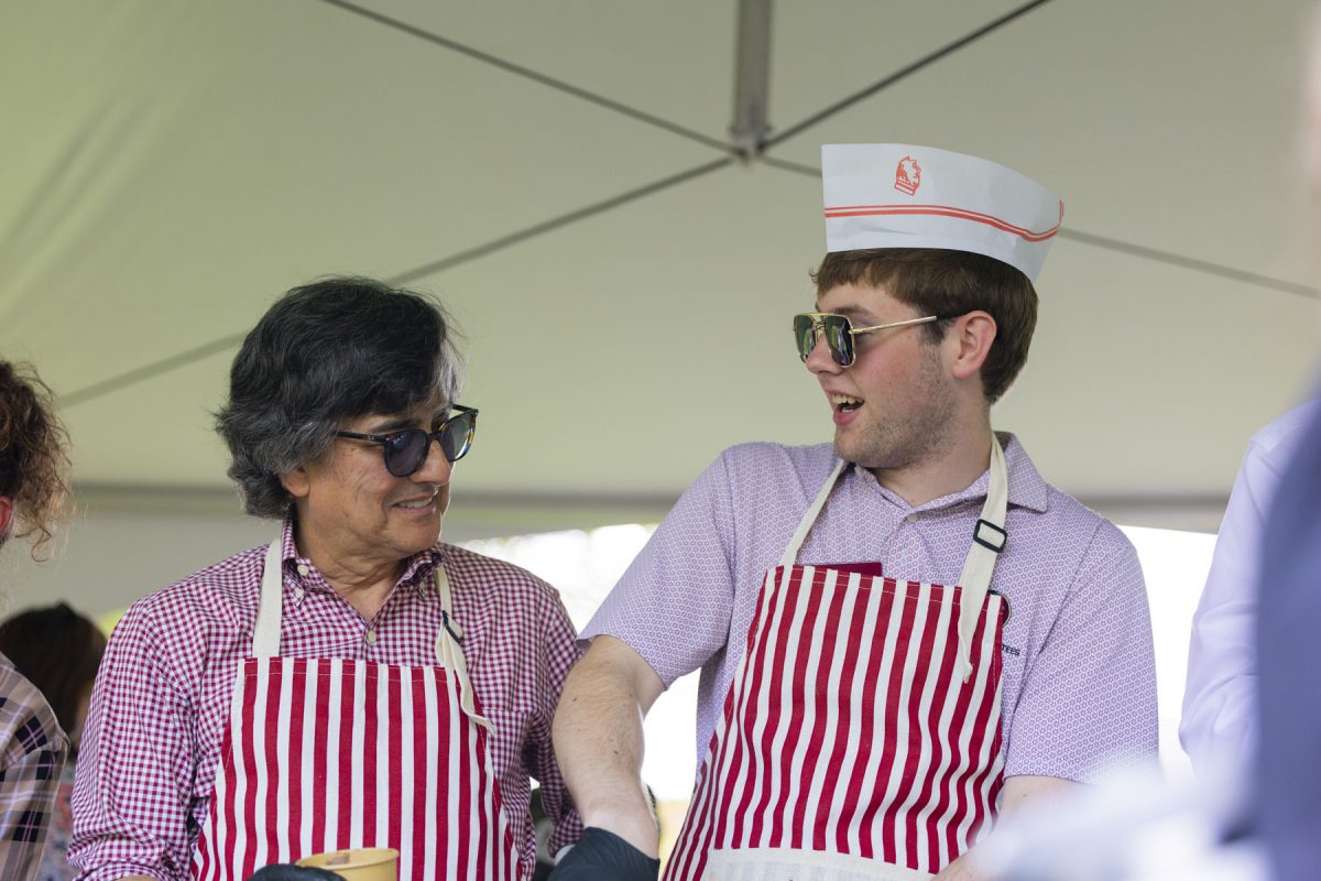 Two men in sunglasses and red and white striped aprons