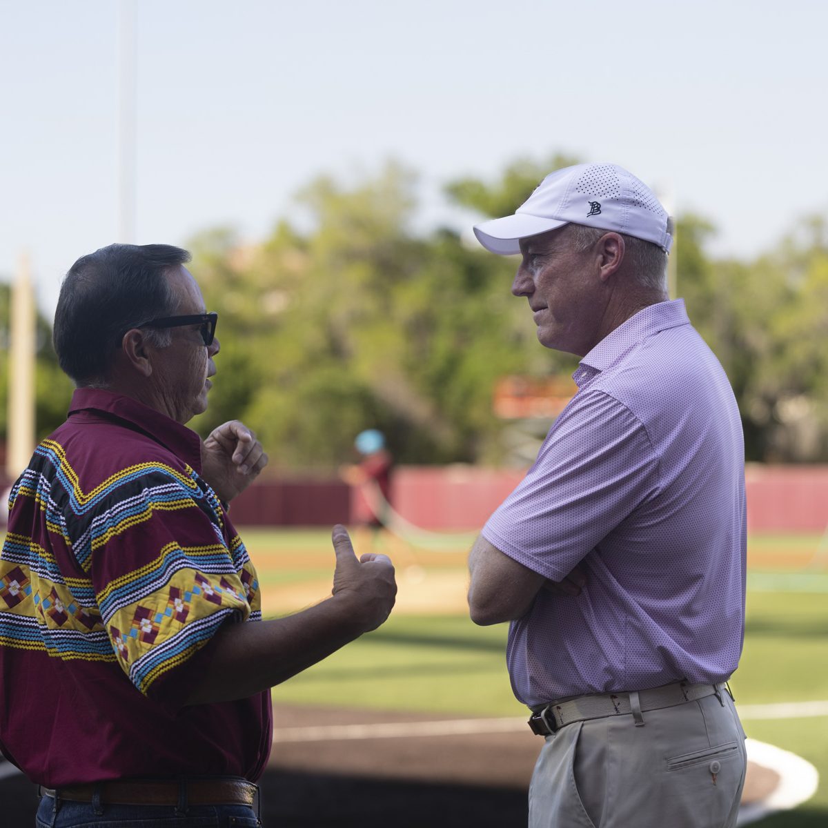 Two men talk on a baseball field