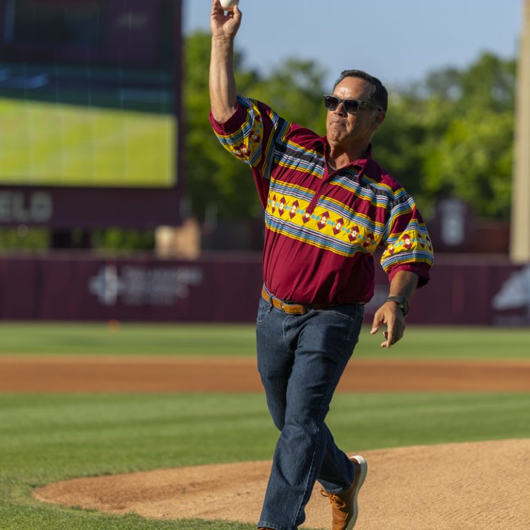 A man on a baseball field is in action as he starts to throw a baseball
