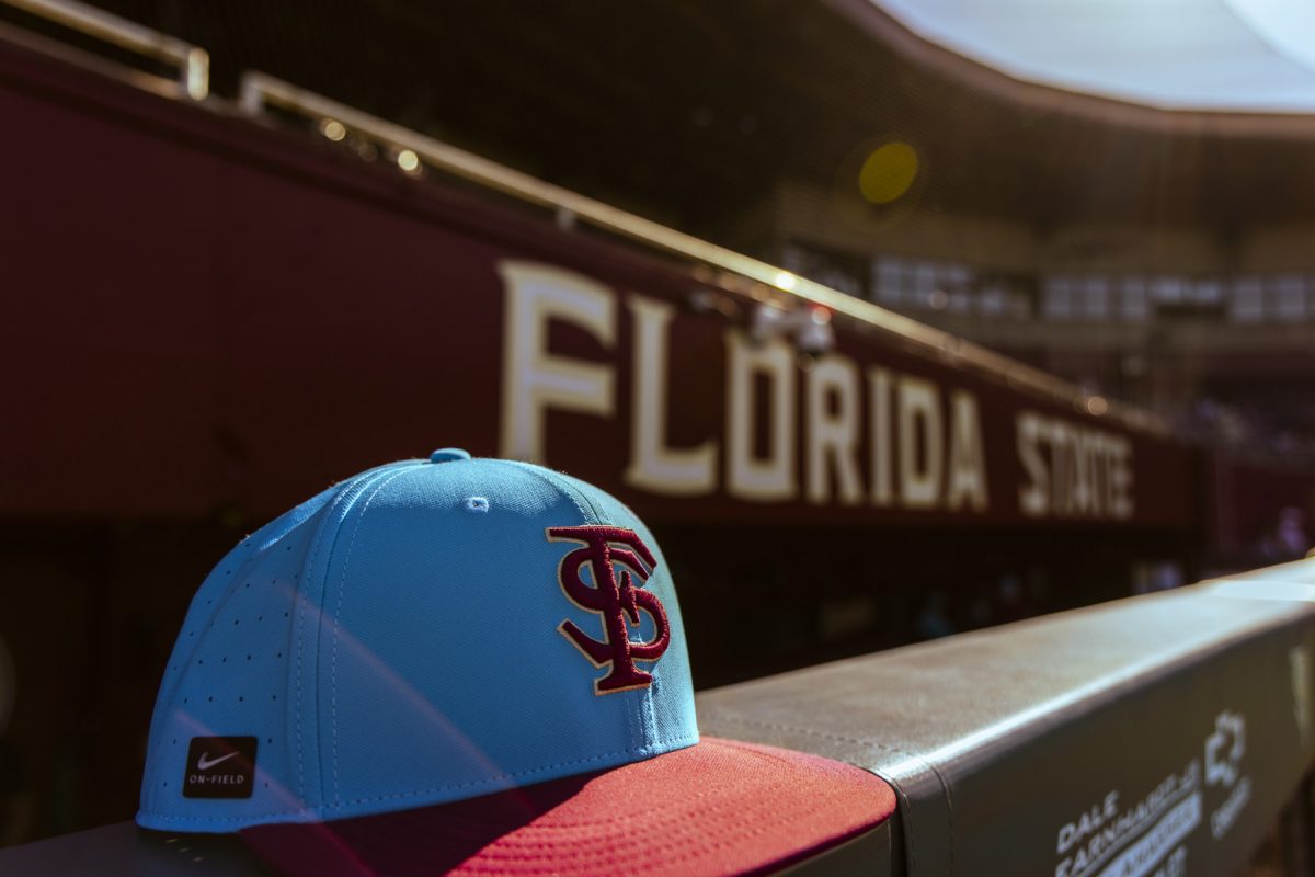 A closeup of a blue and red FSU baseball hat sitting on a ledge at a stadium