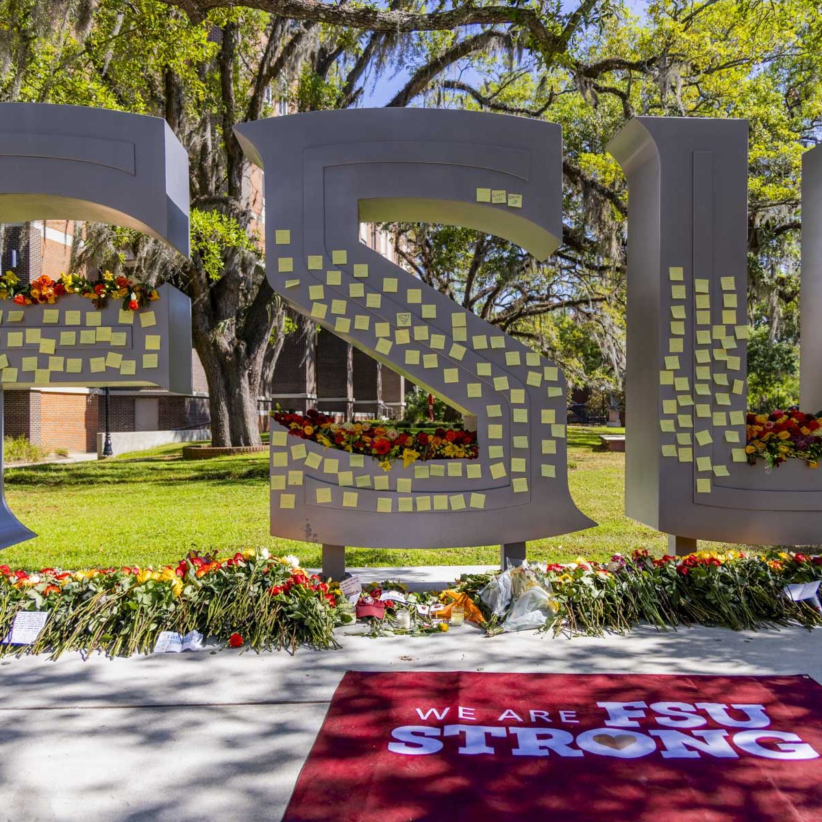 The FSU letters outside the student union are covered in notes and flowers as a temporary memorial