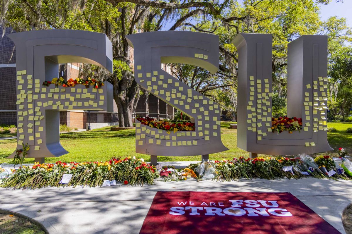 The FSU letters outside the student union are covered in notes and flowers as a temporary memorial