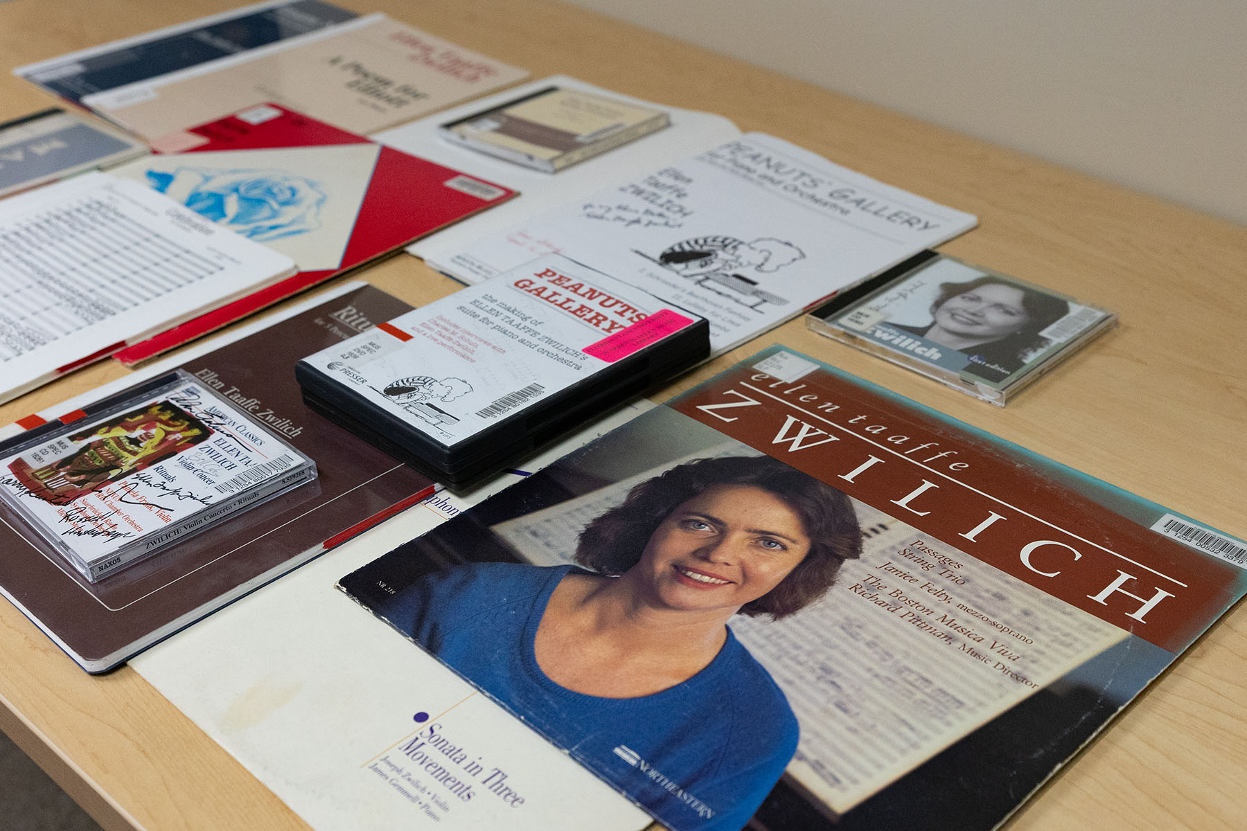 Many papers, folders and photos sit on a table in an intentional manner