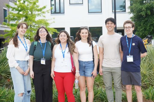 Six student attendees from the ACC Meeting of the Minds conference pose for a photo outside