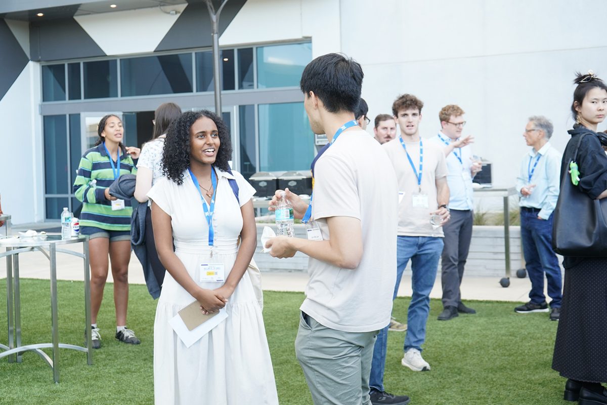 A female attendee speaks with a male attendee outside during the ACC Meeting of the Minds conference