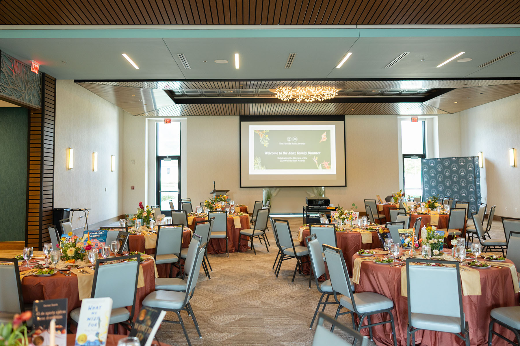 A room with many decorated tables and a screen in the front of the room