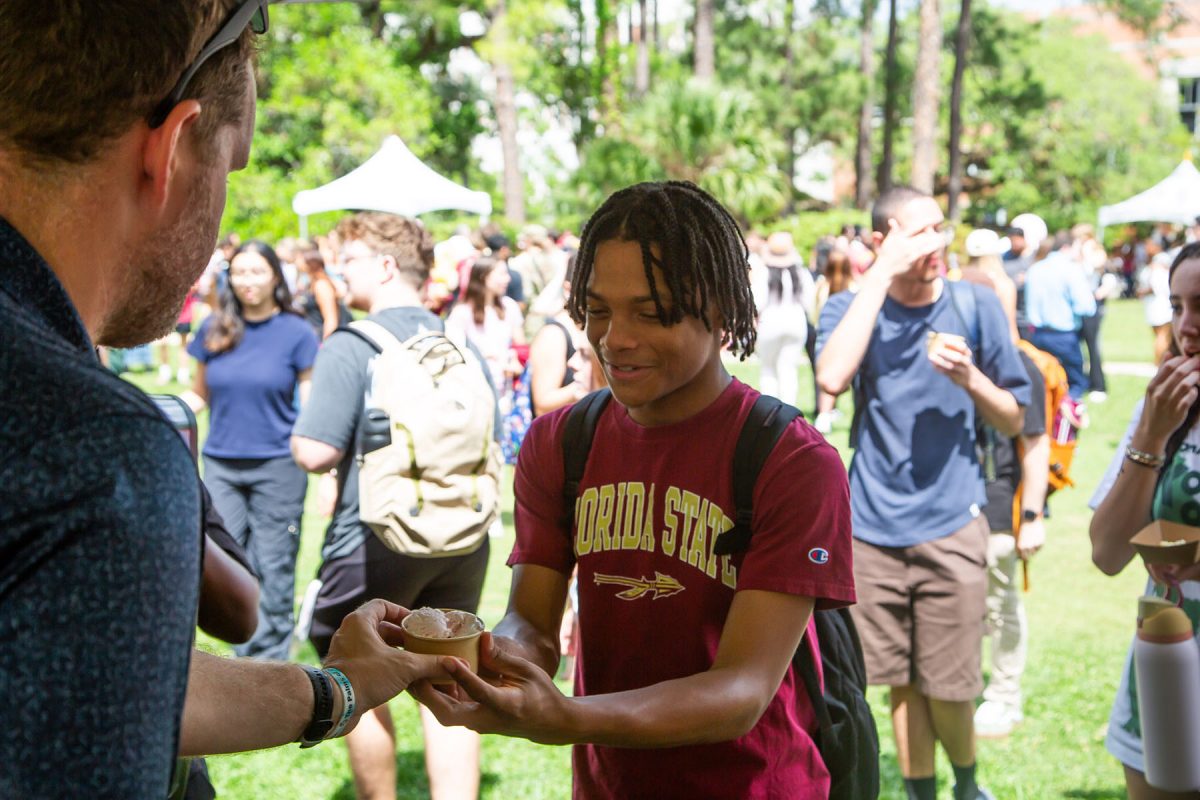 A man hands a student a cup of ice cream