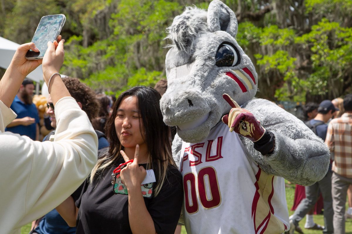 A student and a mascot pose for a photo