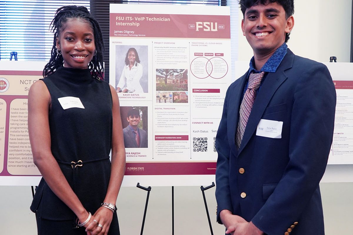 A young man and woman standing in front of a poster prensentation.