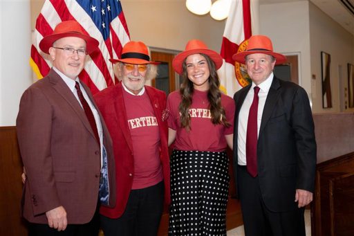 The speakers for Red Hat Day pose in their red hats from left, Wertheim College Dean Michael D. Hartline, Dr. Herbert Wertheim, student Jaclyn Madson and FSU President Richard McCullough.