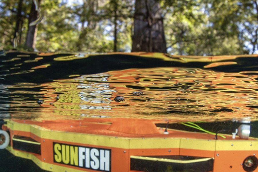 An orange and yellow underwater autonomous vehicle with the word 