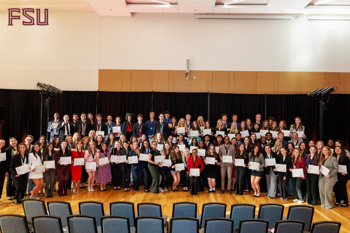 The 100 inductees for the 2026 Torchbearer 100 pose for a photo on stage in the FSU Student Union Ballroom