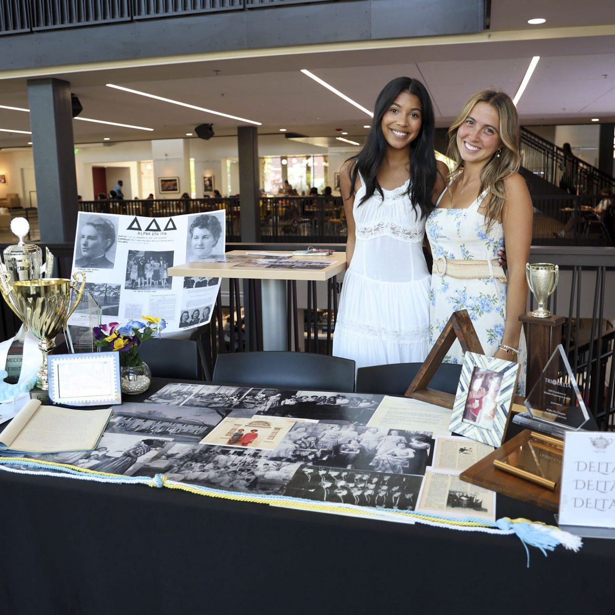 two women standing behind of a table displaying old fsu artifacts