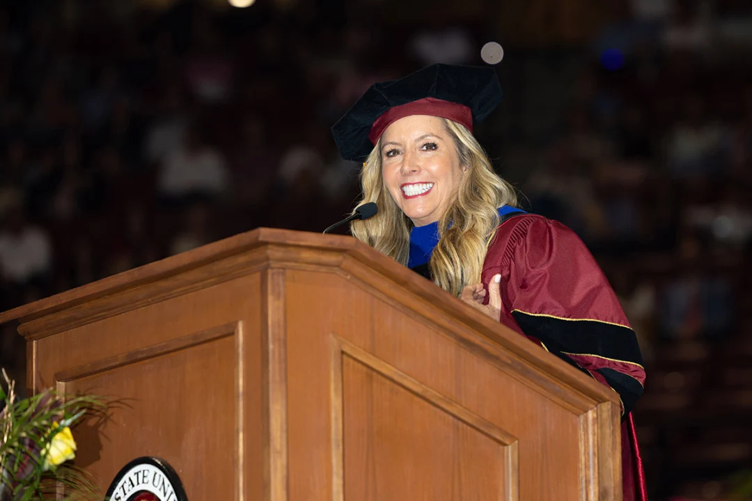 Sara Blakley smiles at the camera while delivering a speech.