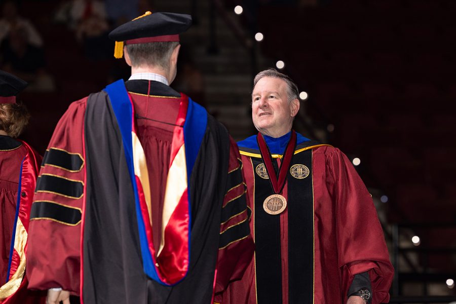 FSU President Richard McCullough shakes a doctoral student's hand.
