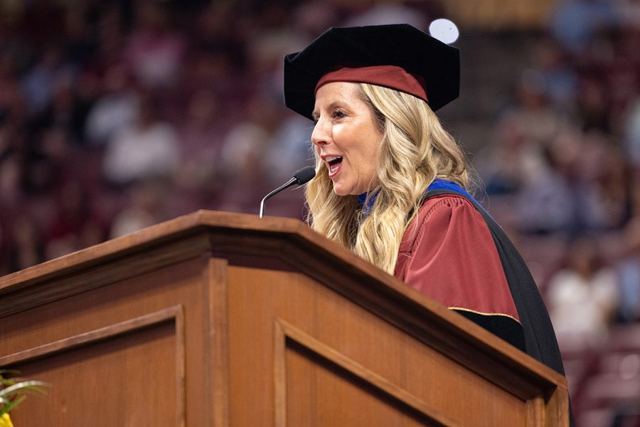 Sara Blakely addresses graduates while standing at the podium during commencement.