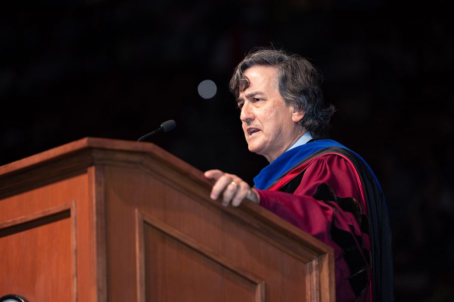 Provost Jim Clark speaks at a wooden lectern during commencement ceremony.
