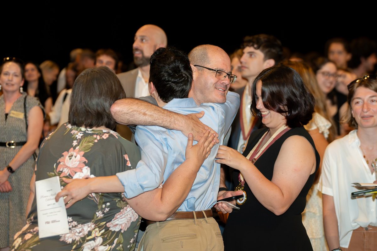 A father embraces his son during the honors medallion ceremony