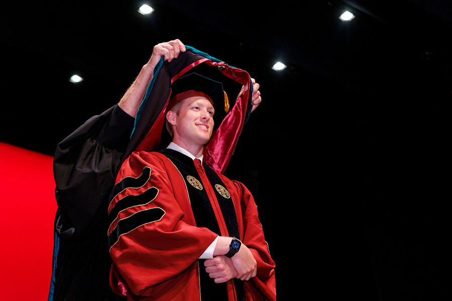 A medical student is hooded at the commencement ceremony.