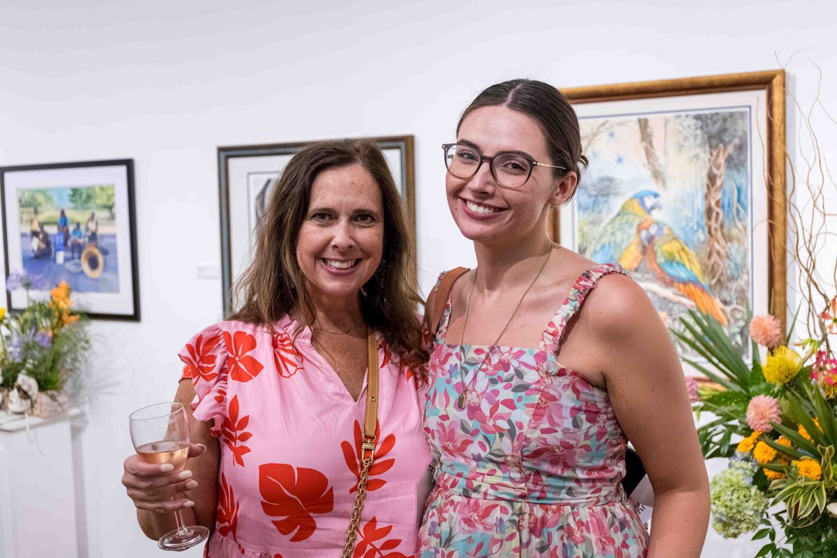Two women smile at the camera at the Art in Bloom event.