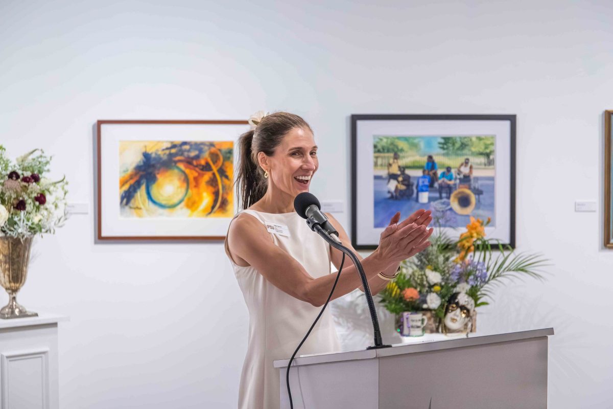 A woman claps and smiles at a podium.