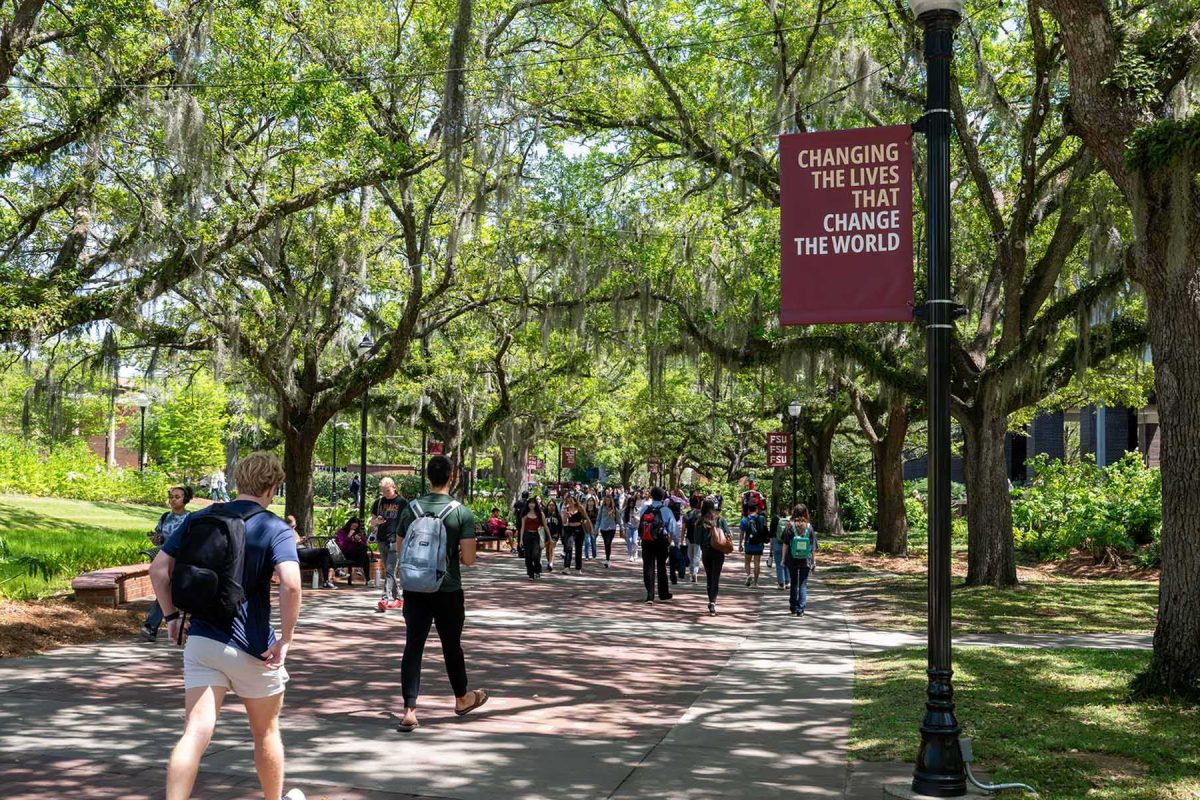 Students walk on Legacy Walk in the middle of FSU's campus.