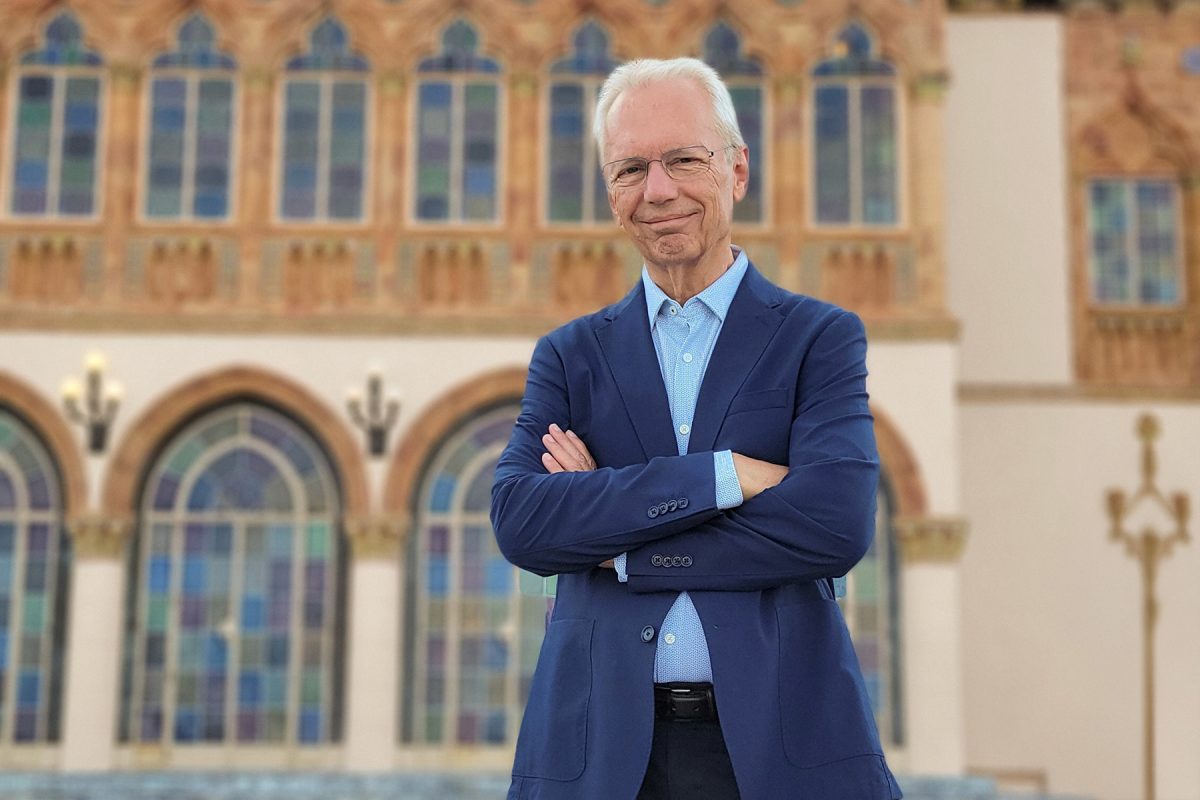 Steven High poses with arms crossed in front of a building at Ringling.