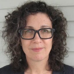 Woman smiling in front of wall panel.