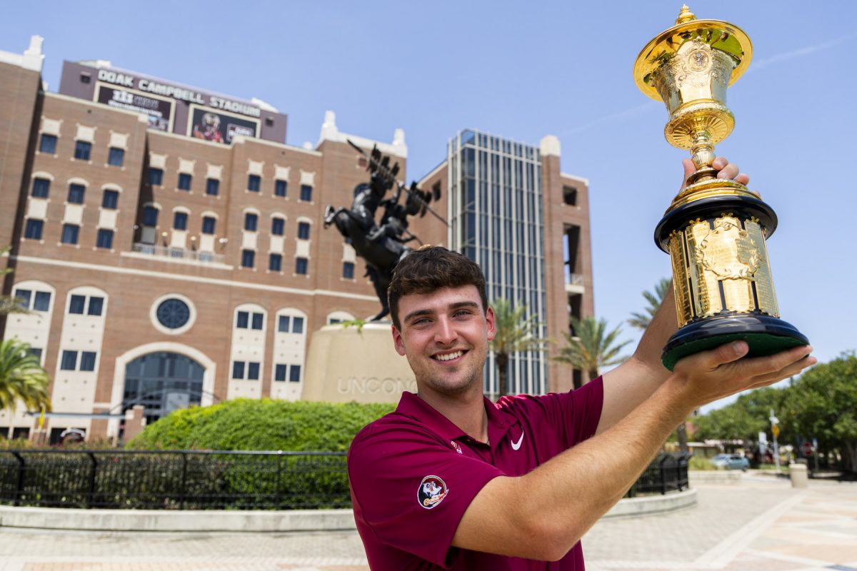 FSU Golfer Jack Whaley with the Havemeyer Trophy in front of the FSU Unconquered Statue