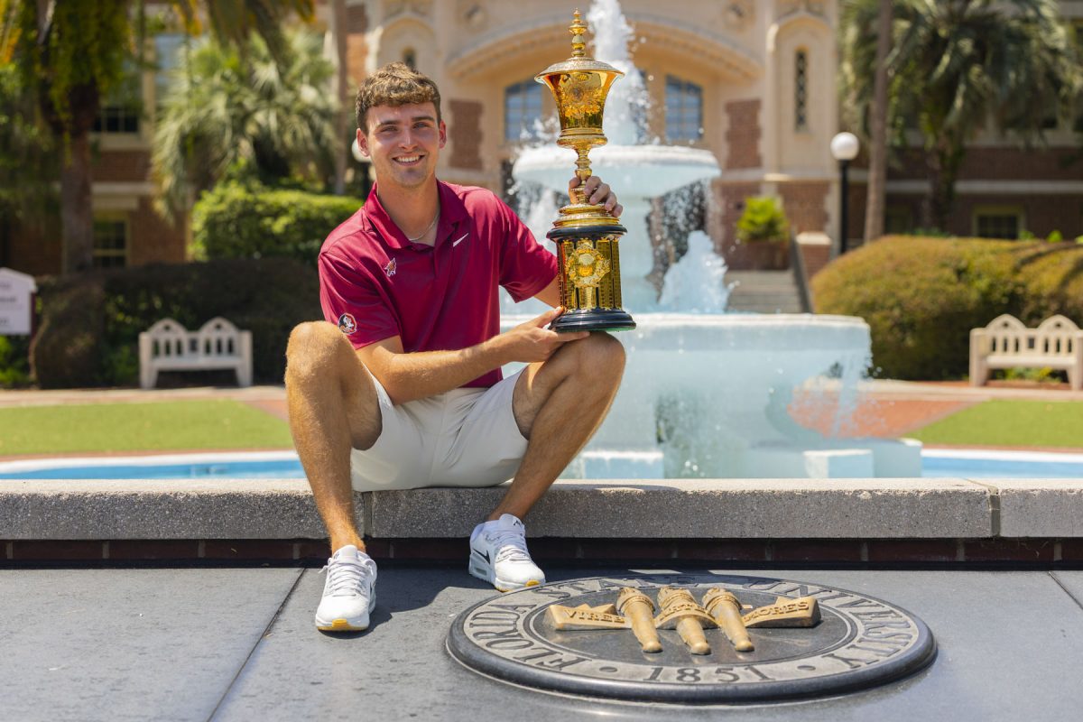 FSU Golfer Jack Whaley with the Havemeyer Trophy in front of the Westcott building