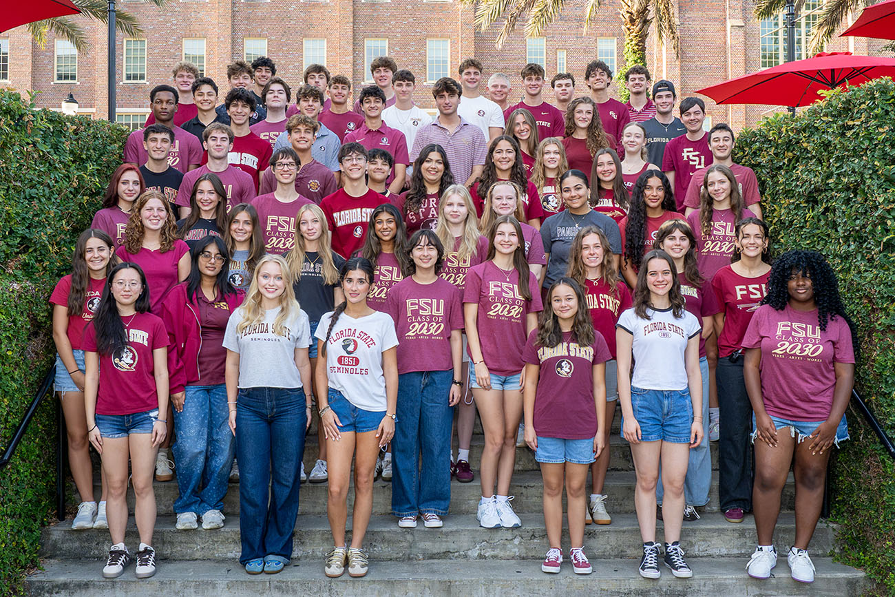 The Class of 2030 Presidential Scholars pose for a group photo with 60 people on an outdoor concrete staircase.