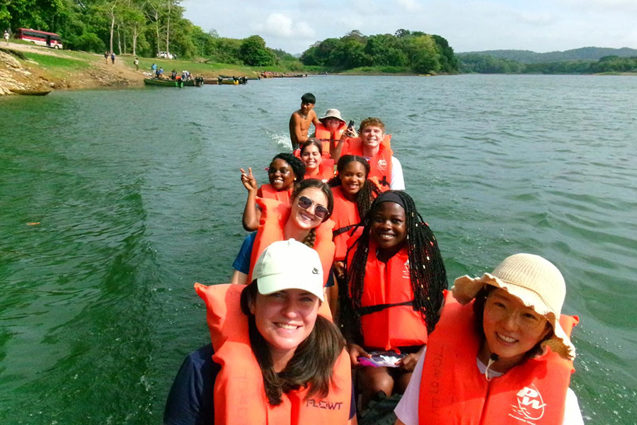 Group of students wearing life jackets on a cayuco.