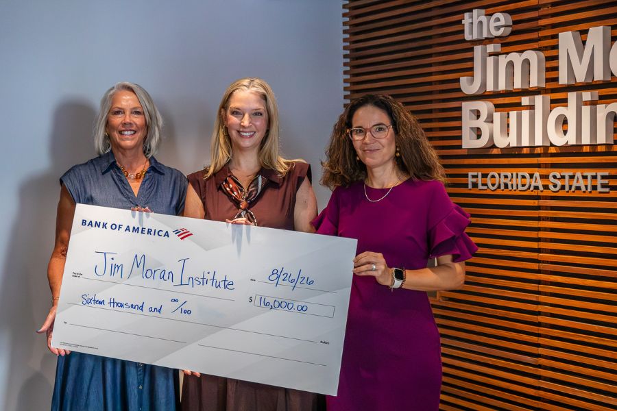 A photo of three individuals hold a $16,000 check from Bank of America.