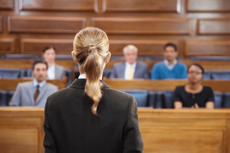 A lawyer in front of a jury in a courtroom.